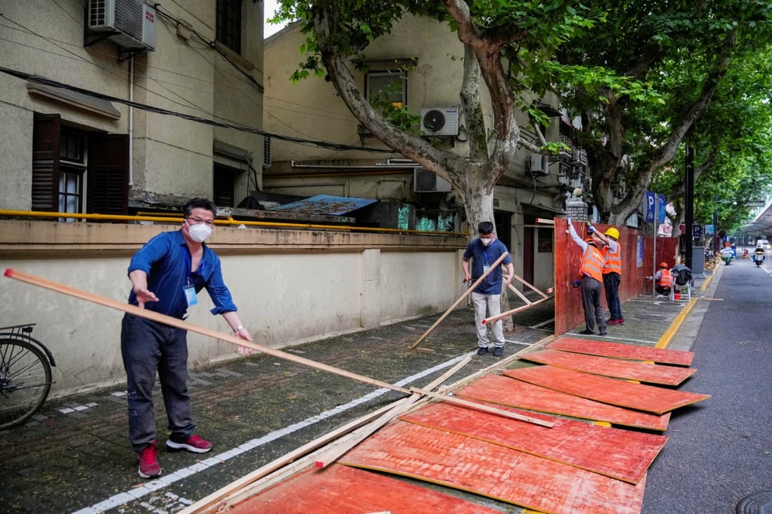 Workers dismantle barriers in a residential area in Shanghai on May 30 as the city prepares to open up. Photo: Reuters