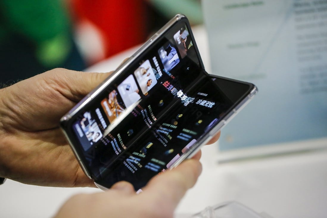 An attendee tries Oppo’s Find N foldable smartphone at a trade show in Barcelona in February 2022. Photo: Bloomberg
