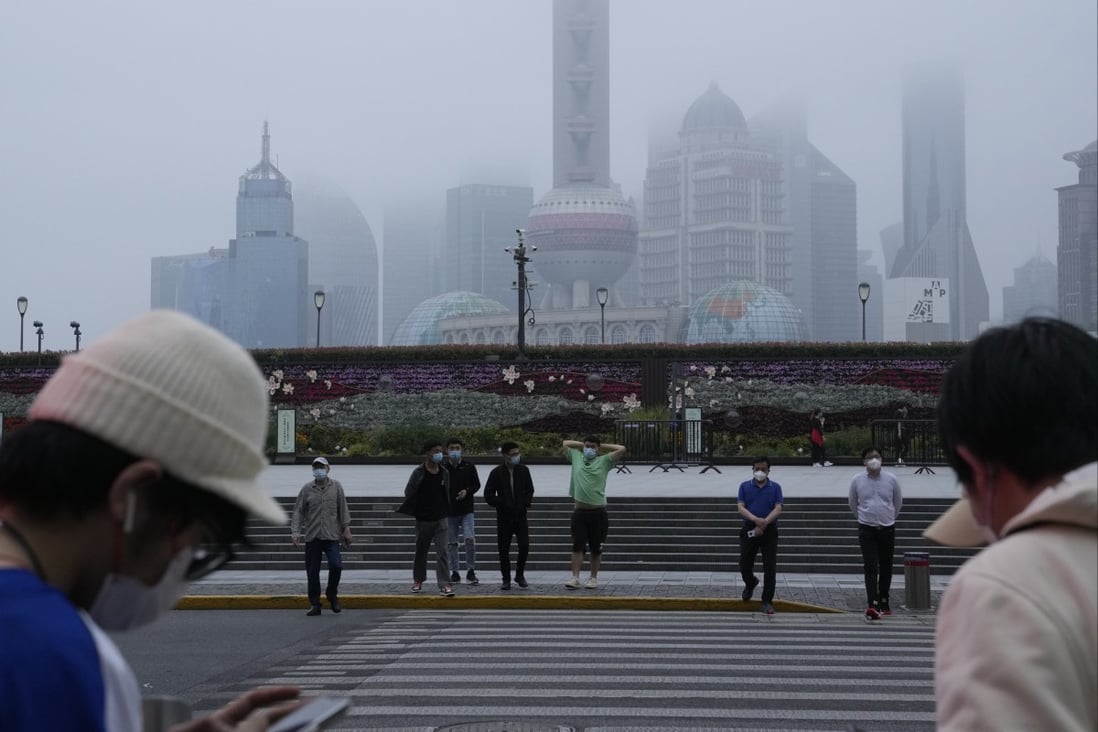 Residents cross the road near the bund as day breaks on the first day of Shanghai reopening on June 1. Photo: AP