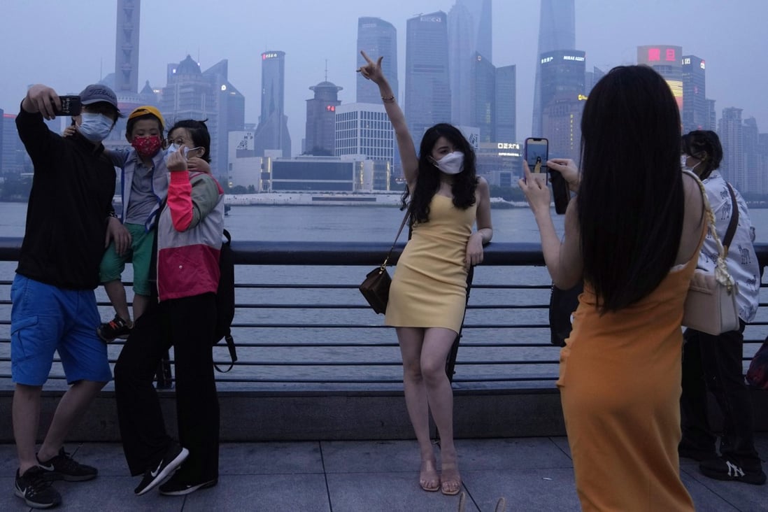 Residents pose for photos along the Bund in Shanghai on June 1 as China’s largest city begins to emerge from a strict two-month lockdown. Photo: AP