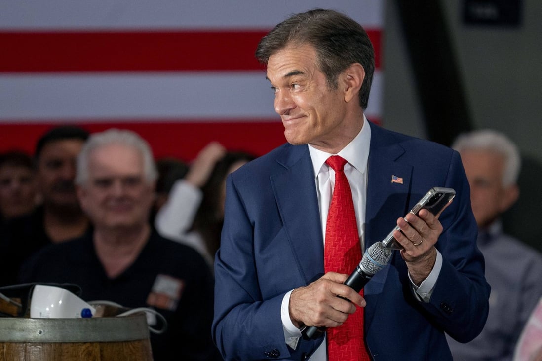 Pennsylvania Republican Senate nominee Mehmet Oz holds his phone to the microphone as former President Donald Trump speaks during a campaign event. Photo: Tom Gralish/The Philadelphia Inquirer/TNS