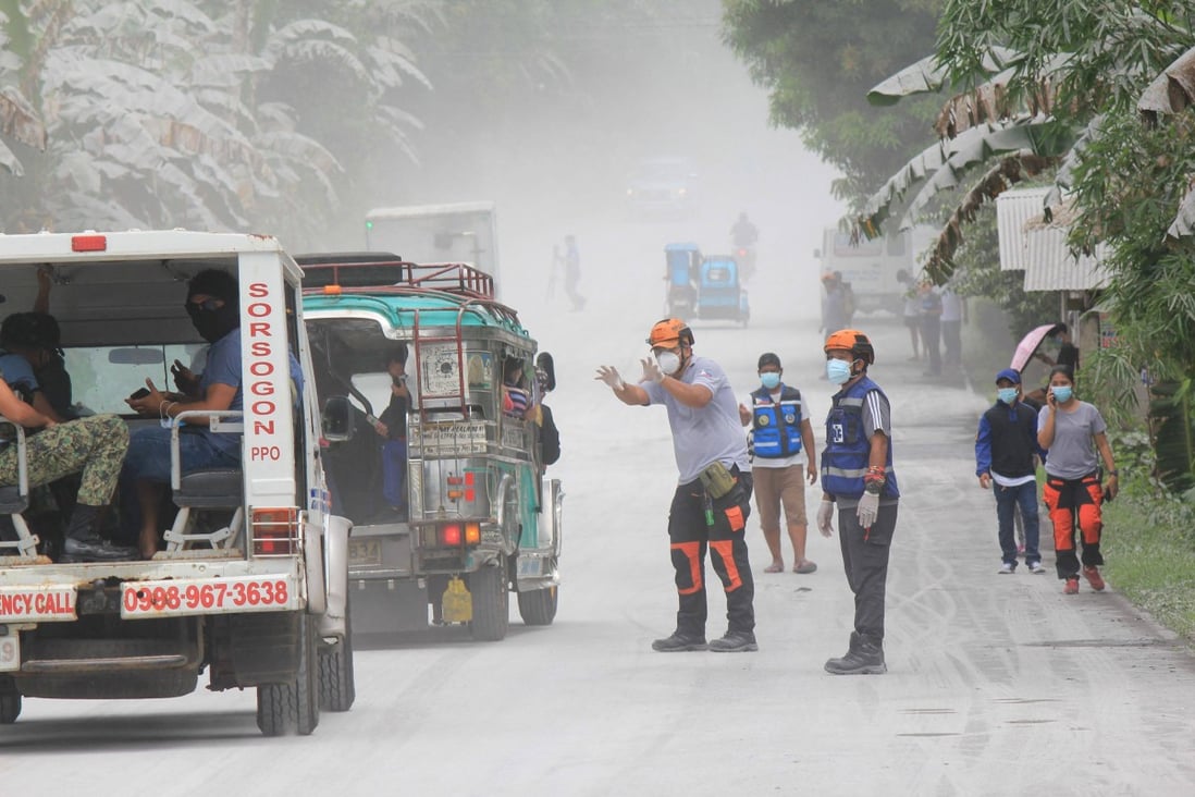 Disaster risk reduction officers guide vehicles on the road at Juban town, Sorsogon Province, after the sudden eruption of Bulusan Volcano. Photo: AFP