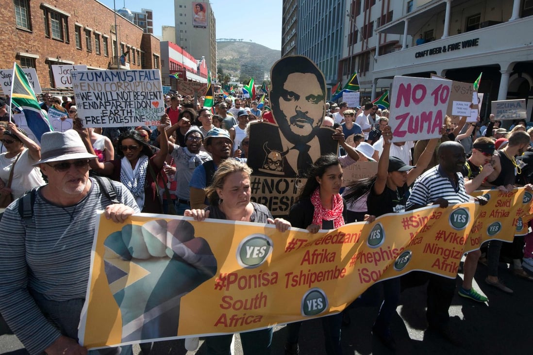 People march with a cut-out poster of Atul Gupta through Cape Town in April 2017, calling on South African President Jacob Zuma to step down. Photo: AFP