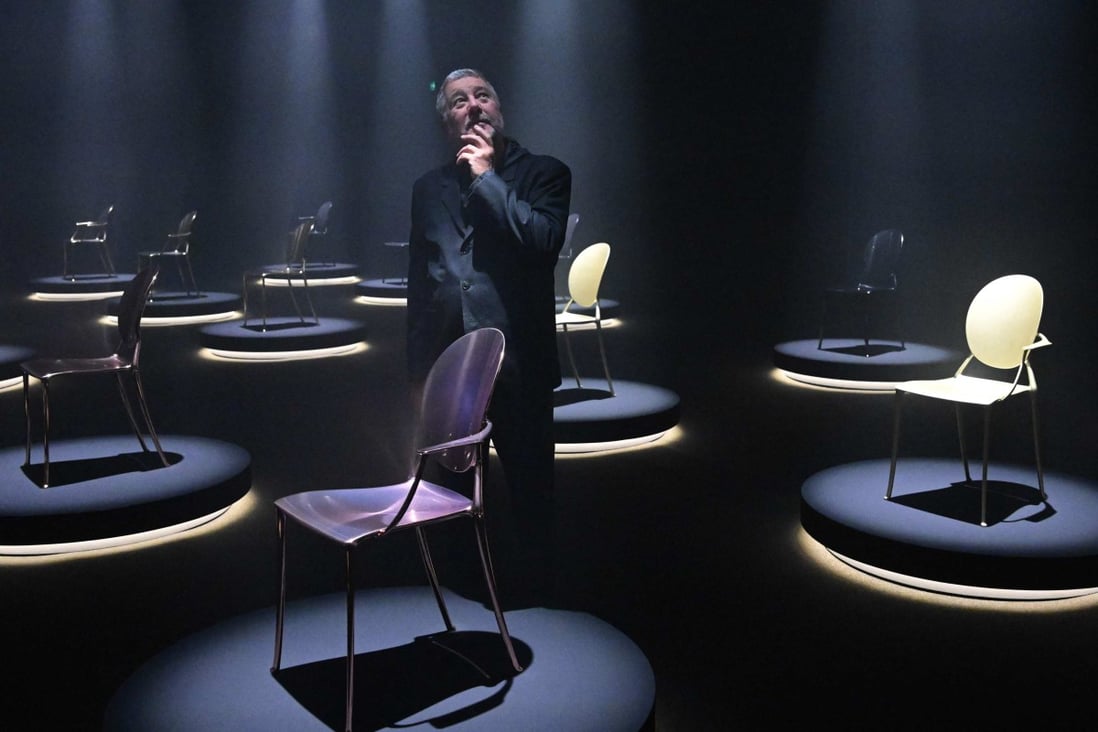French designer Philippe Starck poses on the eve of the opening of the Salone del Mobile furniture fair in Milan with models of “Miss Dior” Medallion chairs he designed for Dior. Photo: AFP