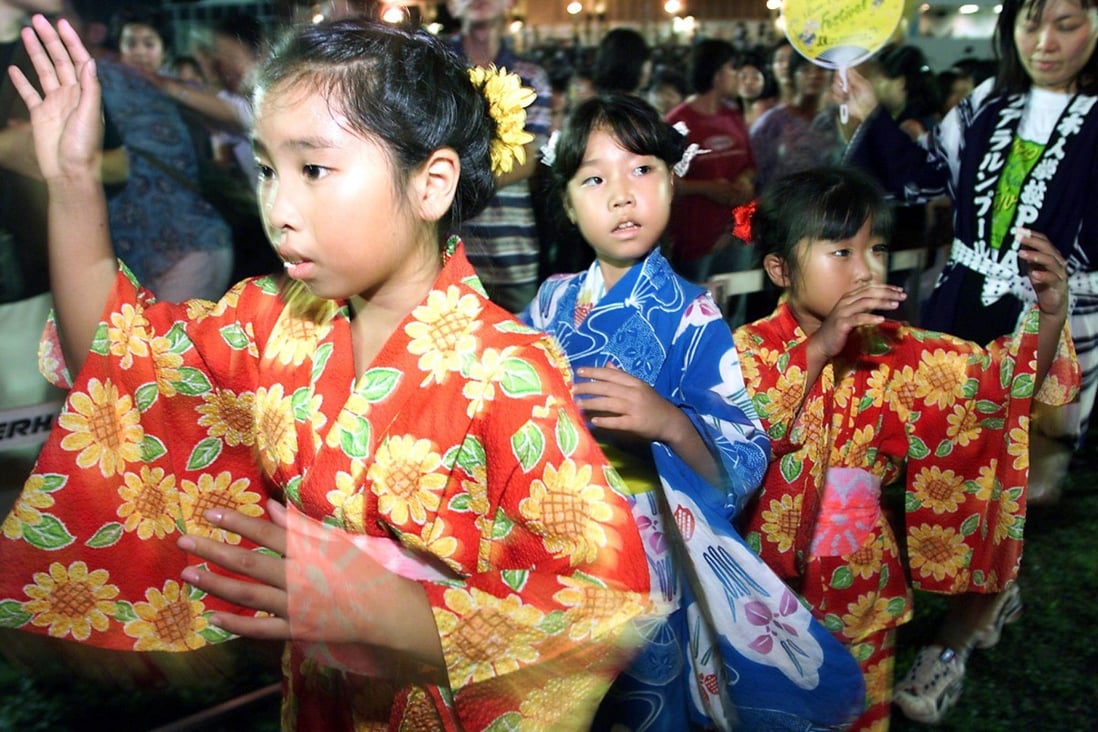 Young girls dressed in Japanese kimonos dance to music during a celebration of the Bon Odori festival in Kuala Lumpur in 1999. Photo: AFP