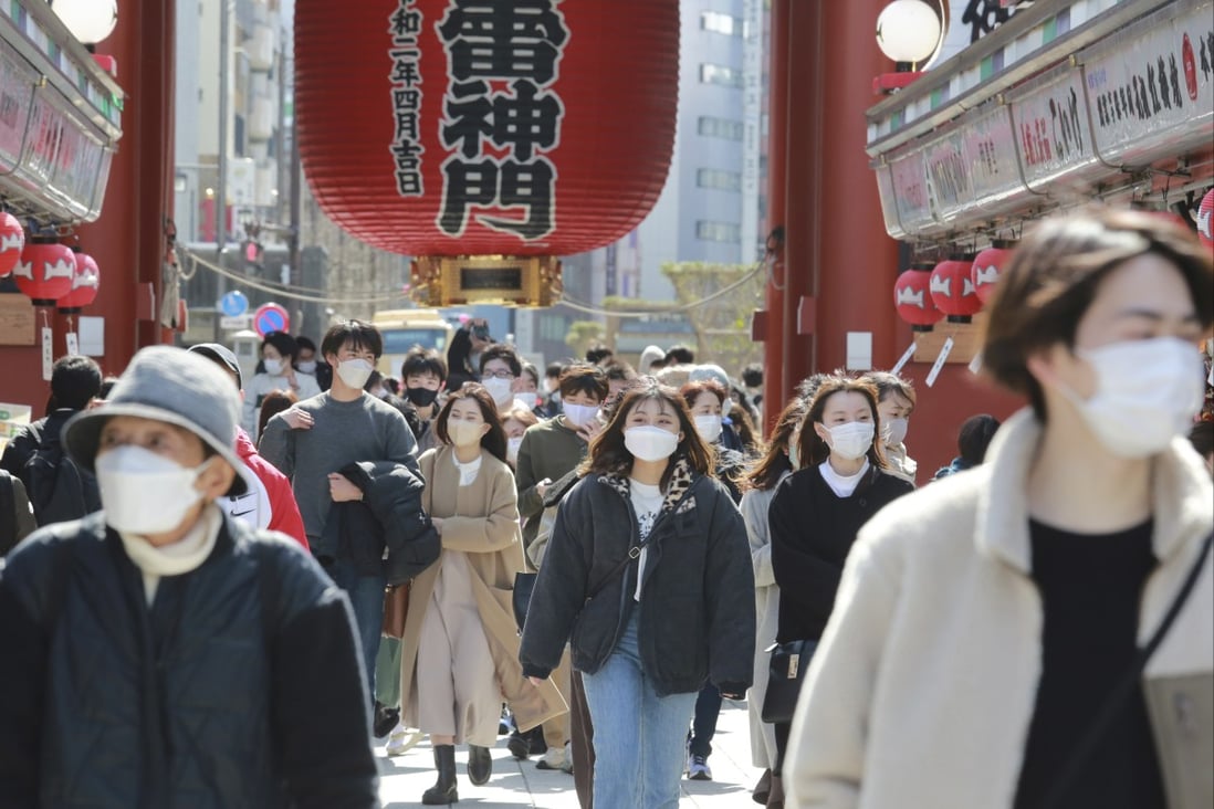 Japanese people wearing face masks to protect against the spread of the coronavirus walk through a shopping arcade in Tokyo. Photo: AP
