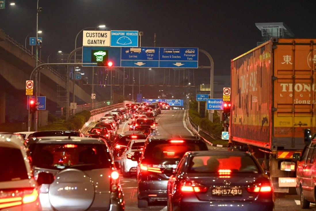 Vehicles form a long queue to enter the Woodlands Checkpoint in Singapore early on April 1, 2022, before crossing the causeway to Malaysia’s southern Johor state, as both countries reopen its borders to all fully vaccinated travellers. (Photo by Roslan RAHMAN / AFP)