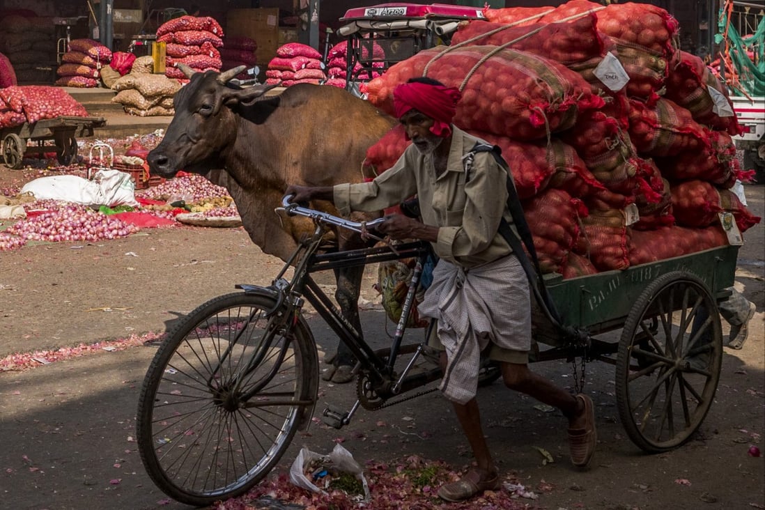 A worker pulls a cart full of vegetables and potatoes at the Azadpur wholesale market in New Delhi. Rising food and energy prices are further weakening the economic outlook in developing countries that were already under stress even before the Covid-19 pandemic. Photo: Bloomberg