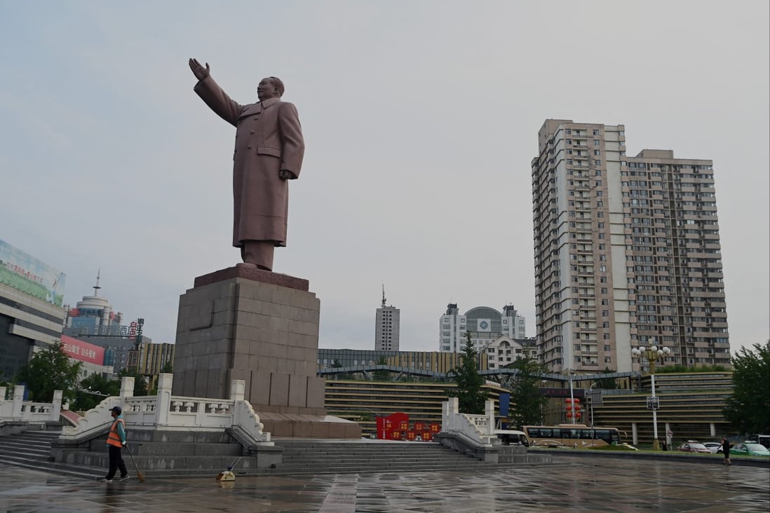 A worker stands in front of a Mao Zedong sculpture in Dandong. The Chinese border city has been locked down since the end of April. Photo: AFP