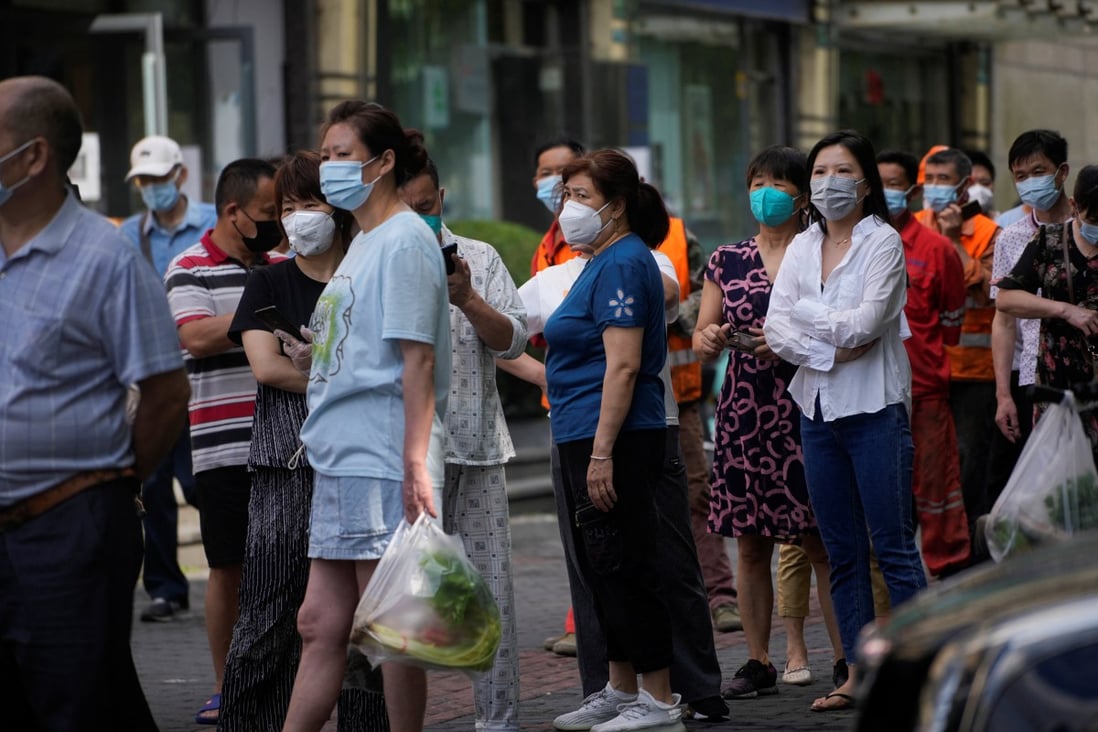 People line up for nucleic acid tests on a street in Shanghai on June 11 as the city reintroduces lockdown measures in some areas to curb new Covid-19 infections. Photo: Reuters