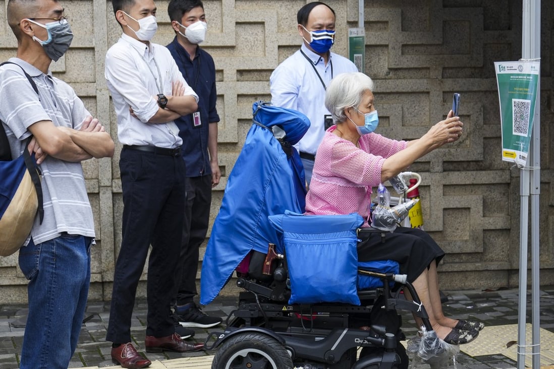 A person uses the Leave Home Safe app to enter the Ambulatory Care Centre at Queen Elizabeth Hospital in Jordan on June 13. Patients must now have a vaccine pass to  enter designated healthcare premises primarily providing non-urgent medical services. Photo: Sam Tsang