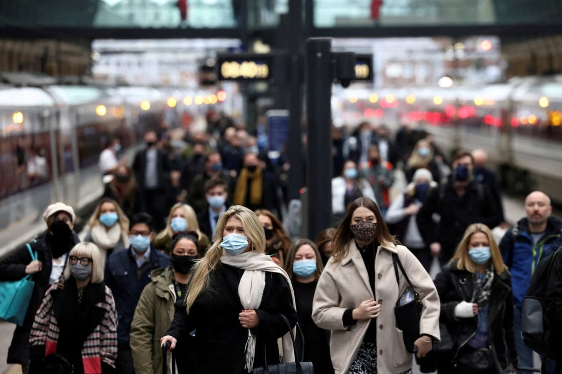 Commuters, most of them wearing face masks, walk along a platform at Kings Cross train station in London during morning rush hour in December. Photo: Reuters