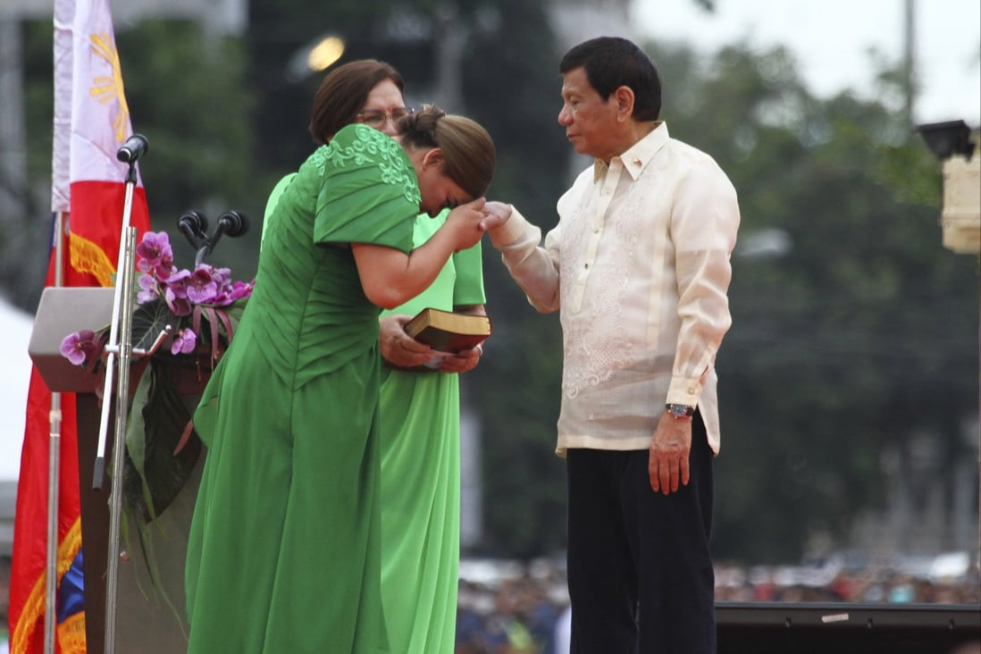 Philippine Vice President-elect Sara Duterte places the hands of her father, outgoing Philippine President Rodrigo Duterte, on her forehead as a sign of respect during her early swearing in ceremony on Sunday. Photo: AP 