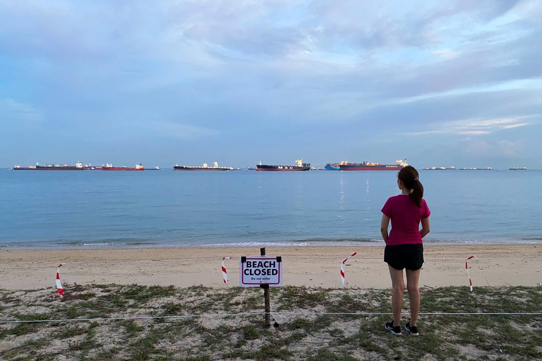 A woman looks at a closed public beach in Singapore in April 2020, during the Covid-19 pandemic. Photo: Reuters