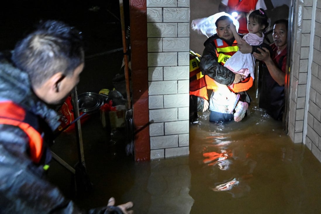 Rescue workers evacuate a child from a flooded building after heavy rainfall in Xinli village of Shaoguan in Guangdong province on Tuesday. Photo: cnsphoto via Reuters