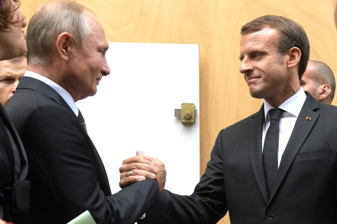 French President Emmanuel Macron (right) greets his Russian counterpart Vladimir Putin in Paris. File photo: Kremlin/dpa