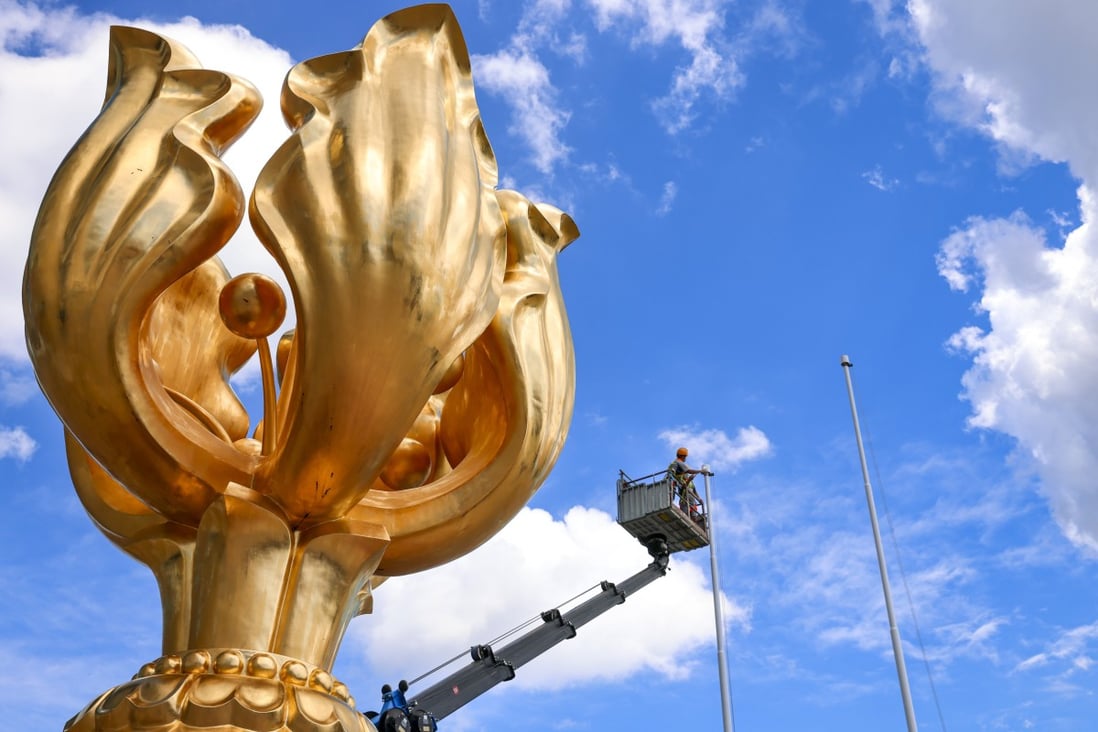 A worker repaints a flagpole at Golden Bauhinia Square in Wan Chai, the usual location for the July 1 flag-raising ceremony.  Photo: Dickson Lee