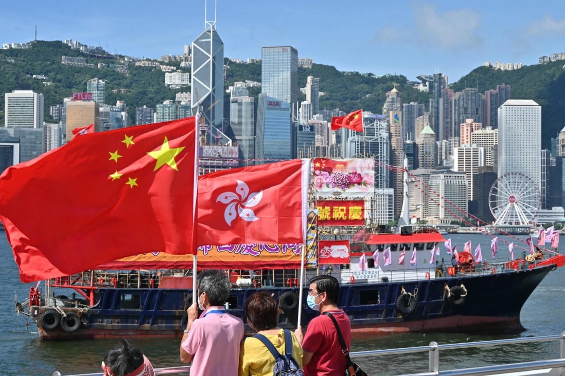 People wave Chinese and Hong Kong flags to mark the 25th anniversary of the handover of Hong Kong from Britain to China on June 28, 2022. Photo: AFP 