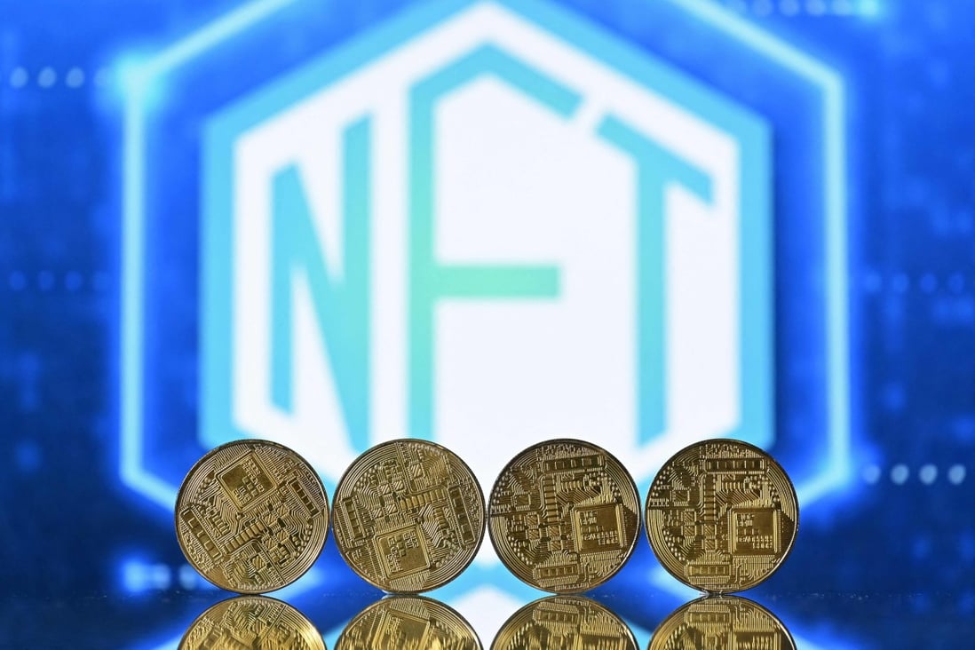 An illustration picture shows souvenir cryptocurrency coins arranged by a screen displaying an NFT logo on December 30, 2021. Photo: AFP