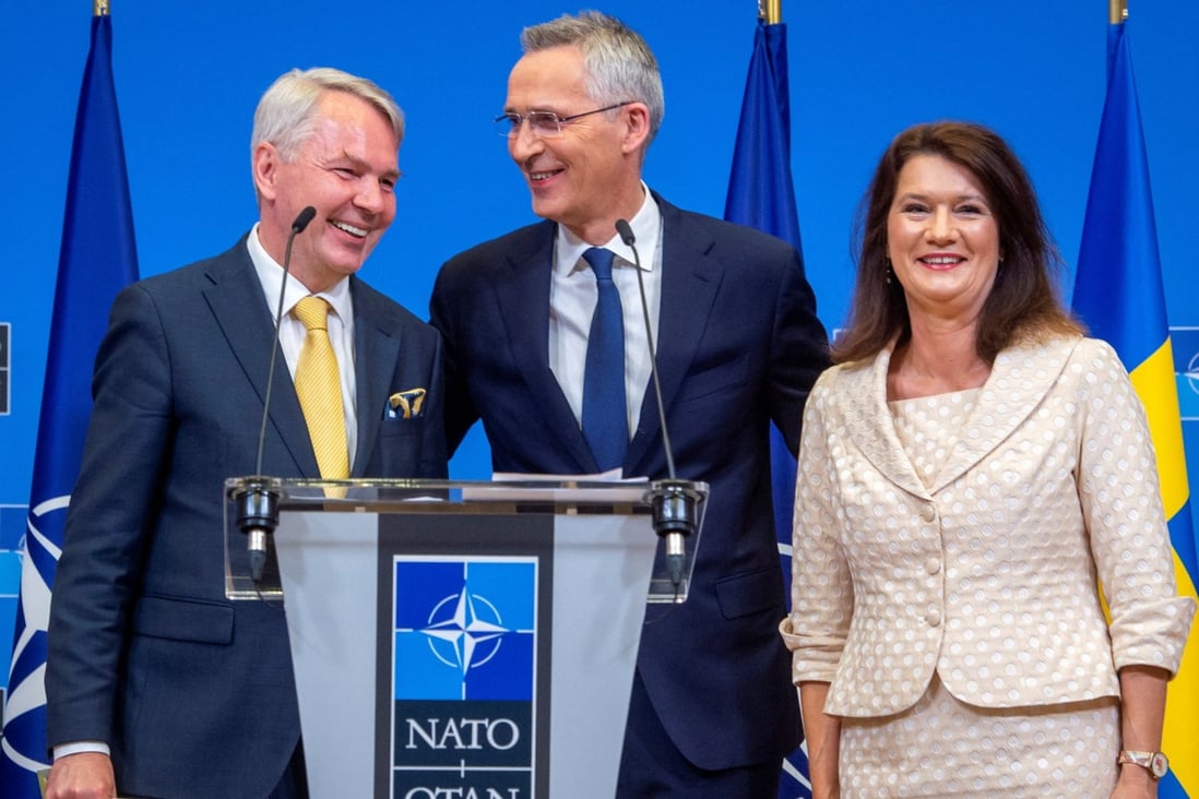Sweden’s Foreign Minister Ann Linde and Finland’s Foreign Minister Pekka Haavisto pose for photographs with NATO Secretary General Jens Stoltenberg as they sign their countries’ accession protocols on Tuesday.  NATO/Handout via Reuters