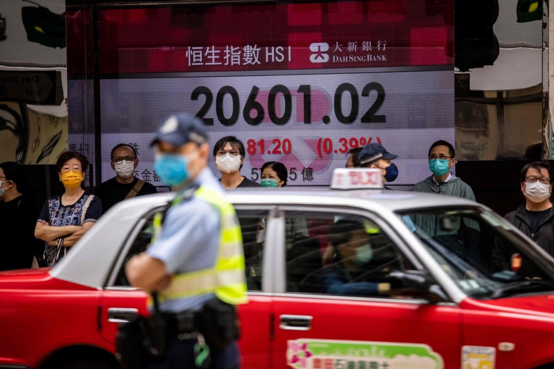 People walk past a display showing the Hang Seng Index in Hong Kong in April 2022. Photo: AFP