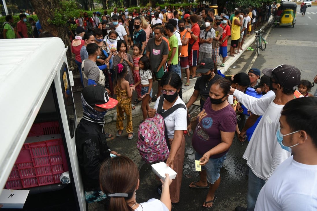 People queue for free meals in Manila last month, distributed by Catholic religious order Society of the Divine Word. Photo: AFP