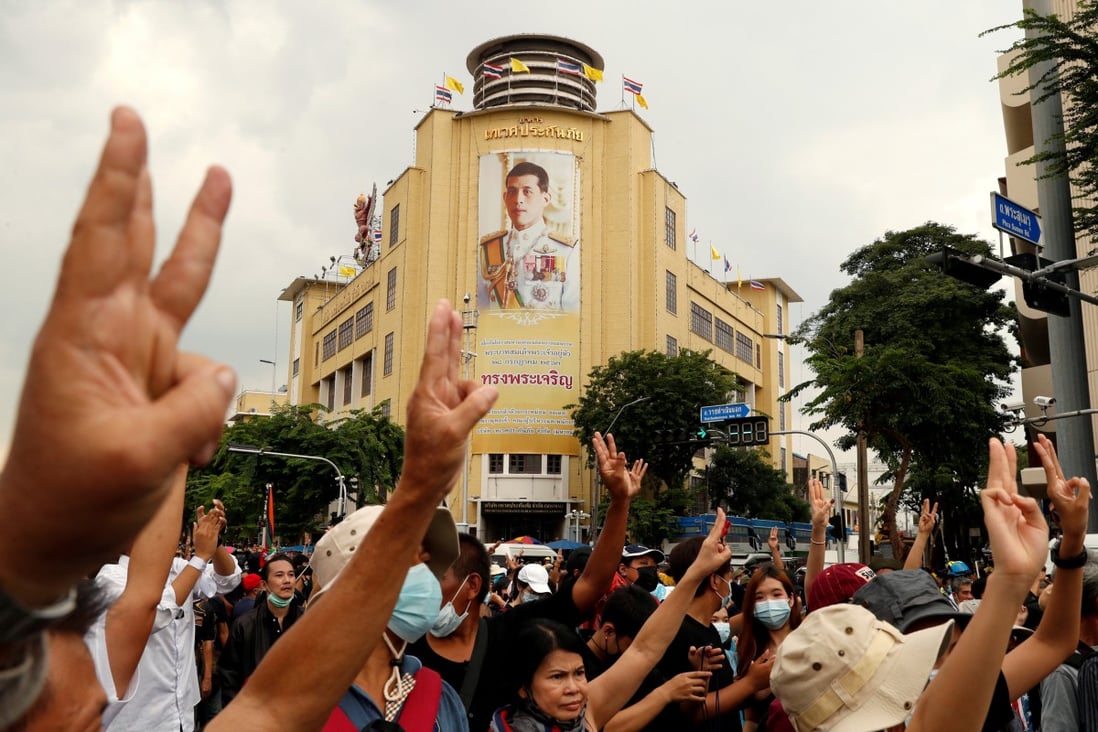 A portrait of King Maha Vajiralongkorn is seen as pro-democracy demonstrators give the three-finger salute during a protest in Bangkok in 2020. Photo: Reuters
