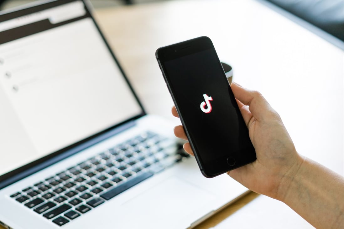 The Douyin/TikTok logo is shown on a smartphone in front of a laptop in this arranged photo. Photo: Shutterstock Images