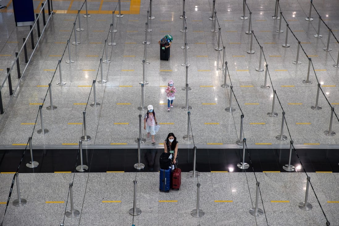 A woman and her children make their way to queue for a bus to their quarantine hotel in the arrival hall at Hong Kong International Airport on July 12. Photo: EPA-EFE