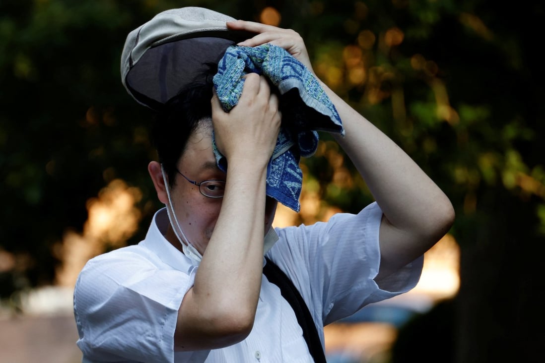 A man dabs his forehead with a sweat towel in a park last month amid Tokyo’s hottest June streak since 1875. Photo: Reuters