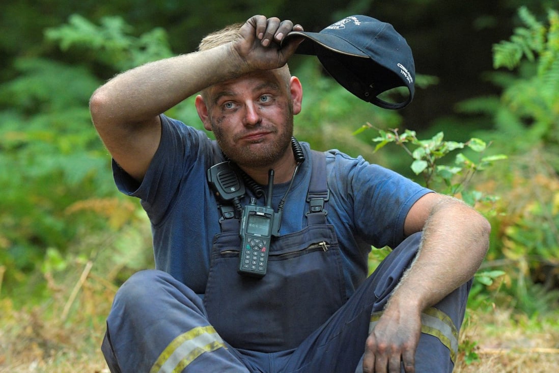 A German firefighter takes a break as he helps to extinguish a forest fire during a heatwave. Photo: Reuters