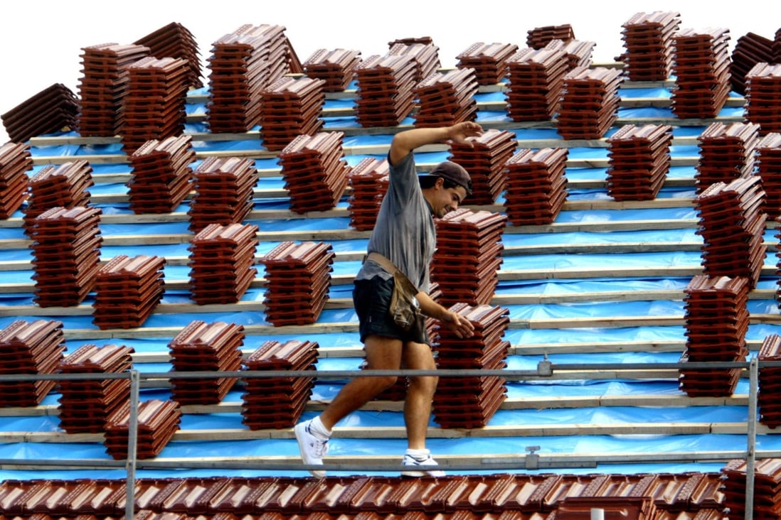 A roof tiler balances on a roof at a residential building site in Sydney on August 1. Photo: Reuters