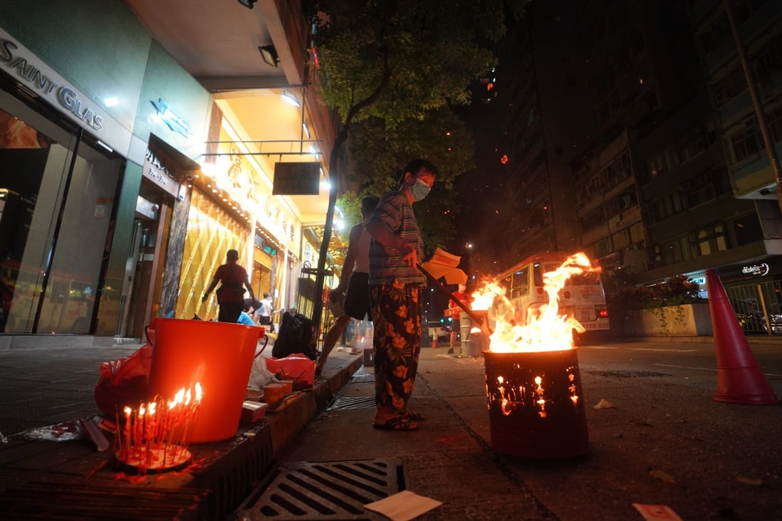 A woman burns offerings on the street during Hungry Ghost Festival. Some other customs during the festival, however, aren’t necessarily grounded in tradition. Photo: Winson Wong