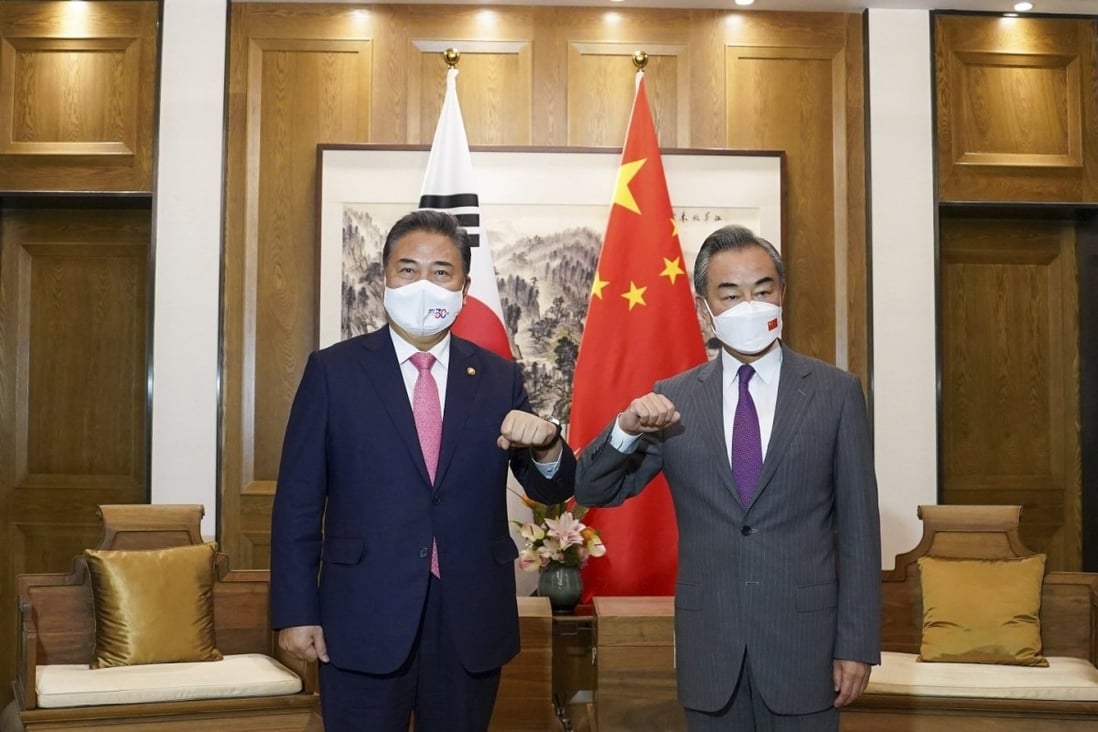 South Korean Foreign Minister Park Jin (left) bumps elbows with his Chinese counterpart Wang Yi in Qingdao, China, on August 9. Photo: South Korea Foreign Ministry via AP