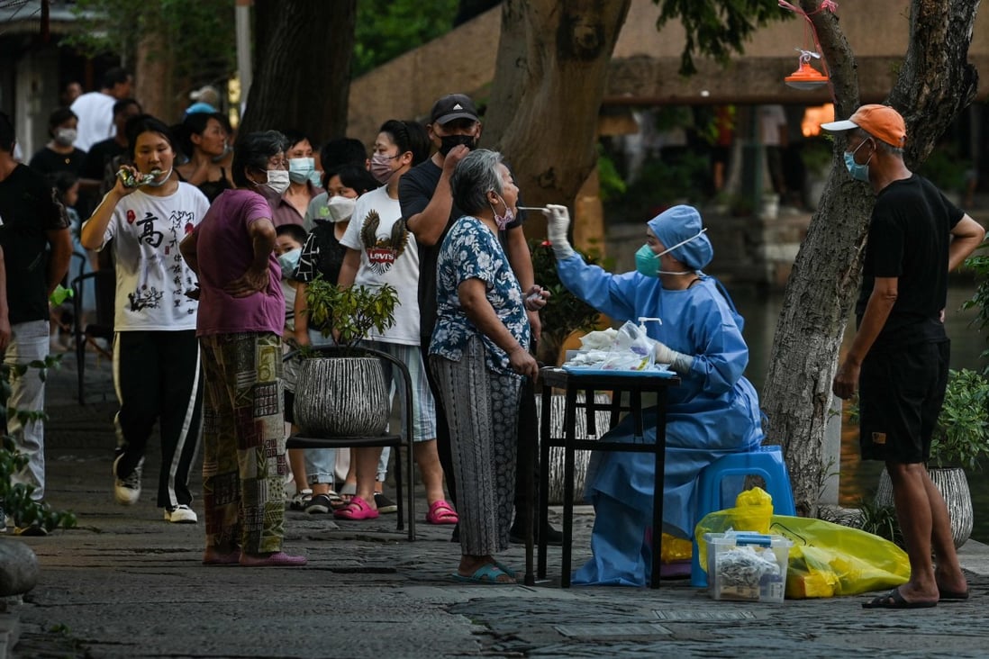A health worker takes a swab sample from a woman to test for Covid-19 in Shanghai. Photo: AFP