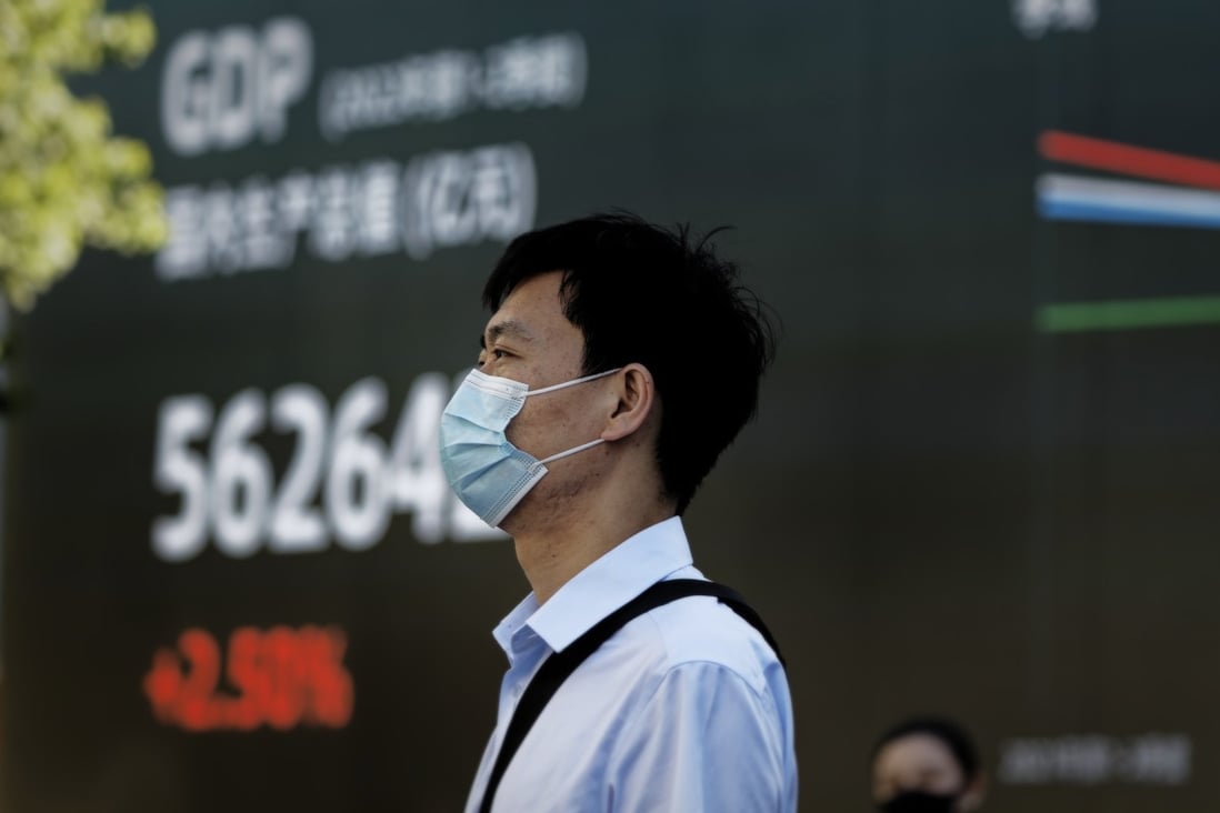A man stands in front of an electronic board showing economic data in Shanghai in August 2022. Photo: EPA-EFE