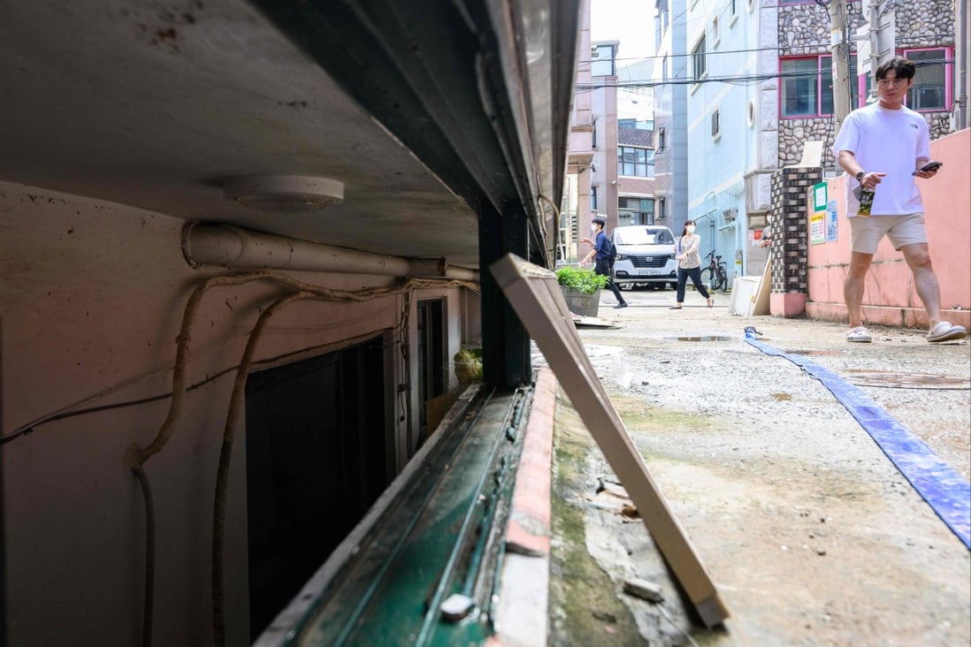 A man walks past an unscrewed security grill for a basement flat known as ‘banjiha’ where three tenants, including a disabled woman and a teenager, died after they were trapped by floodwaters in their basement home in Seoul on August 11. Photo: AFP
