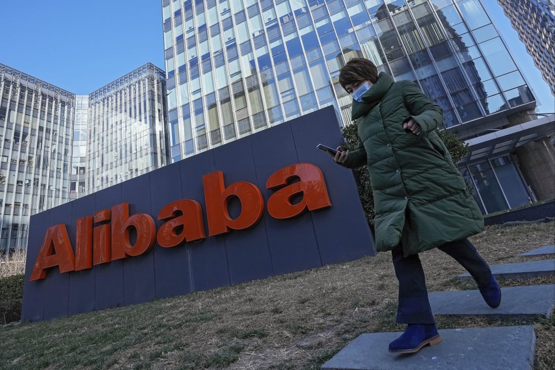 A woman walks past the offices of Alibaba in Beijing. Photo: AP Photo