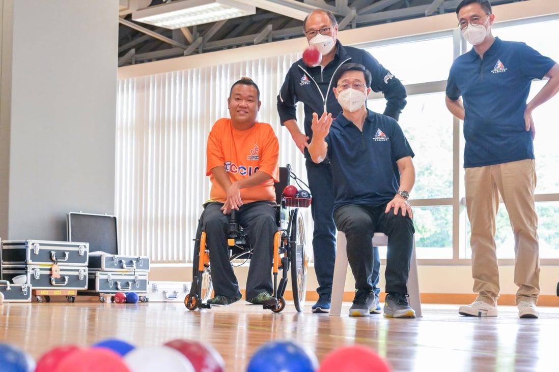 Chief Executive John Lee (seated, right) tries his hand at boccia as he meets Paralympic medallist Leung Yuk-wing (far left) at Hong Kong Sports Institute on Tuesday. Photo: HKSI