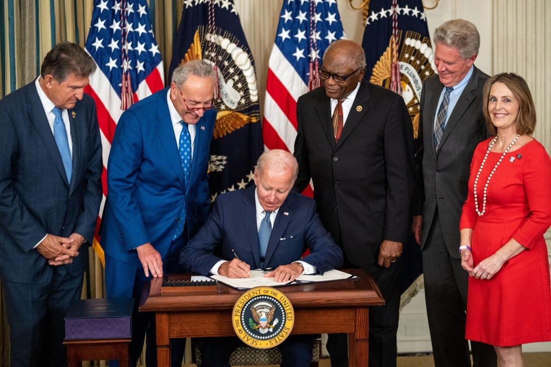 US President Joe Biden, flanked by Democratic members of Congress, signs the Inflation Reduction Act into law. Photo: TNS