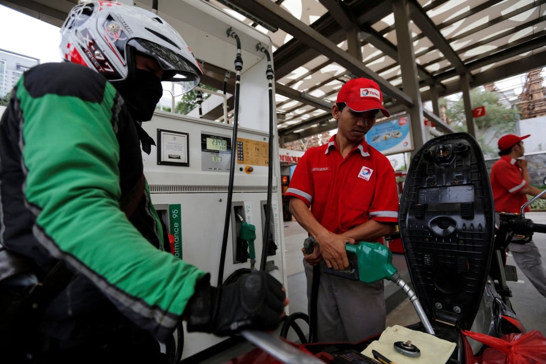 A petrol station employee fills up a motorcycle for a customer in Jakarta. File photo: Reuters