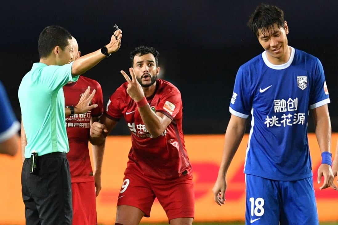Henrique Dourado (second right) of Henan SSLM speaks with the referee during a Chinese Super League match against Wuhan Three Towns. Photos: Xinhua