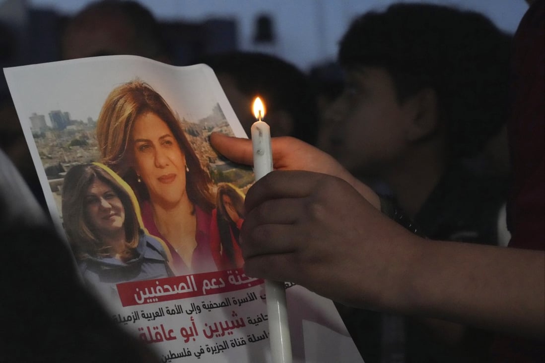 A Palestinian holds a picture of slain Palestinian-American Al Jazeera journalist Shireen Abu Akleh, during a candlelight event to condemn her killing. File photo: AP