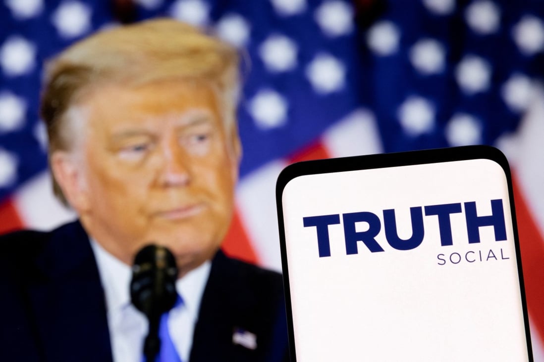 The Truth social network logo seen on a smartphone in front of a display of former US president Donald Trump in this picture illustration taken February 21, 2022. Photo: Reuters