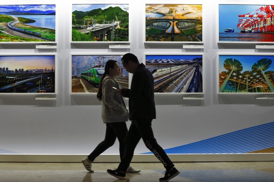 People walk past a display board showcasing China’s construction projects at the media centre of the Belt and Road Forum in Beijing, on April 27, 2019. Photo: AP