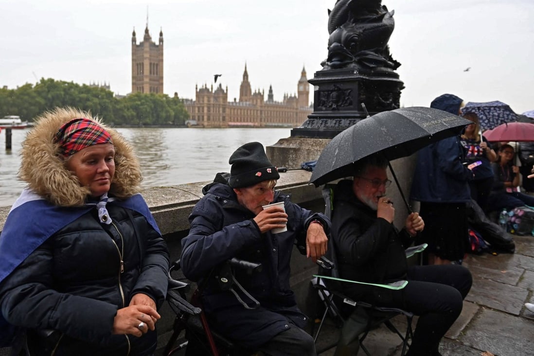 Members of the public queue in the rain along the south bank of the River Thames, as they wait to pay their respects when Queen Elizabeth lies in state. Photo: AFP