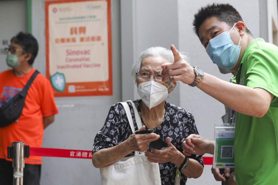 A man directs an elderly woman as she waits to be vaccinated at Kwun Chung Sports Centre in Jordan on June 6. Photo: Xiaomei Chen