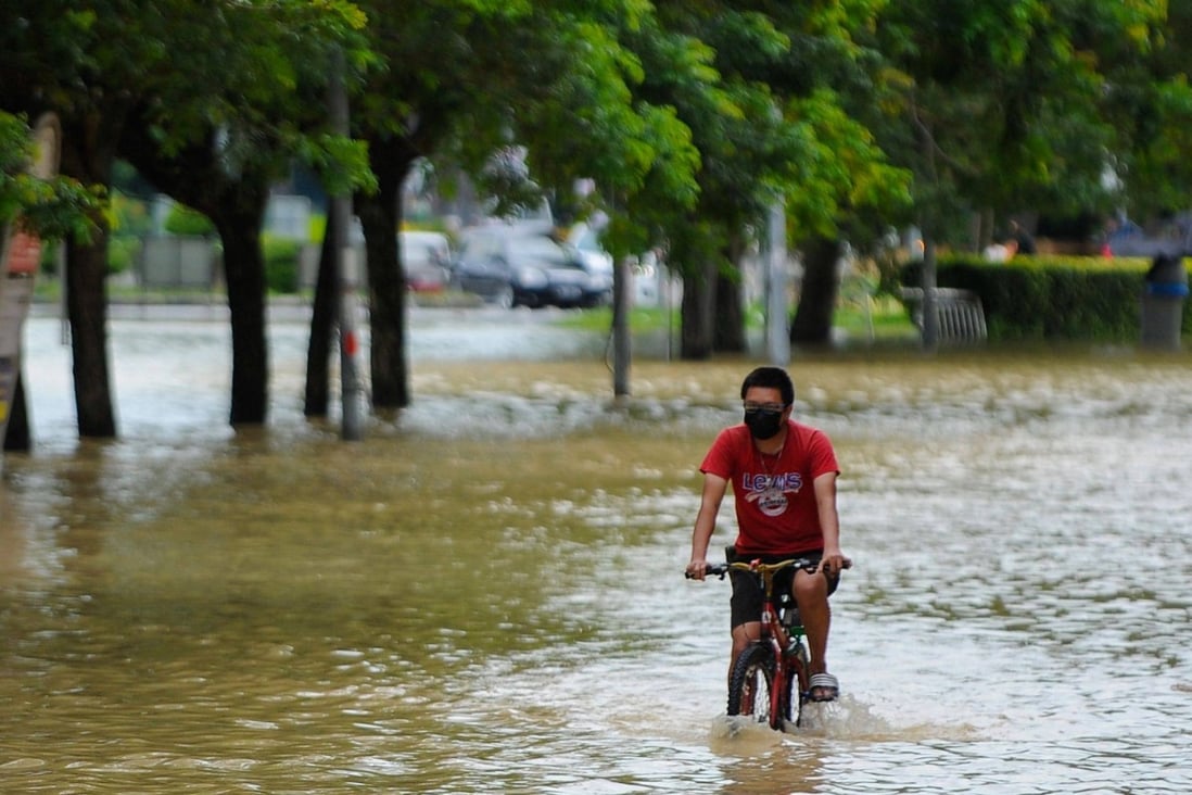 A man cycles through floodwaters in Batu Berendam in Malaysia’s southern coastal state of Malacca on January 3. Photo: AFP