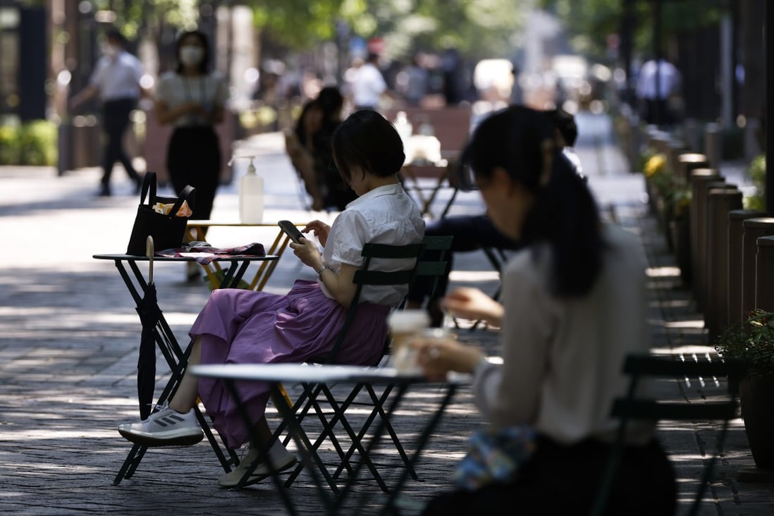 Women sit in the shade in the Marunouchi district of Tokyo, on July 1. In Japan, amid official encouragement, companies are beginning to embrace a four-day working week. Photo: Bloomberg