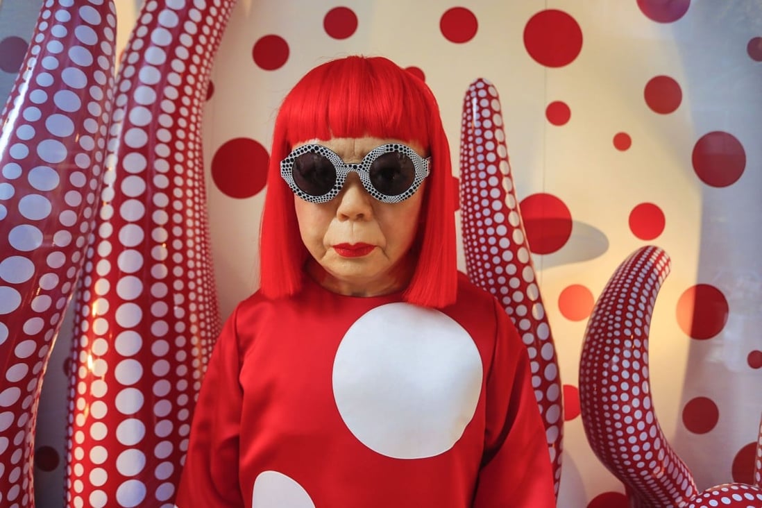 Yayoi Kusama poses against one of her works featuring her signature polka dot motif in Hong Kong in 2012. au milieu de son oeuvre à Hong Kong, Photo:  Jose-Fuste Raga/Gamma-Rapho via 
 Getty Images